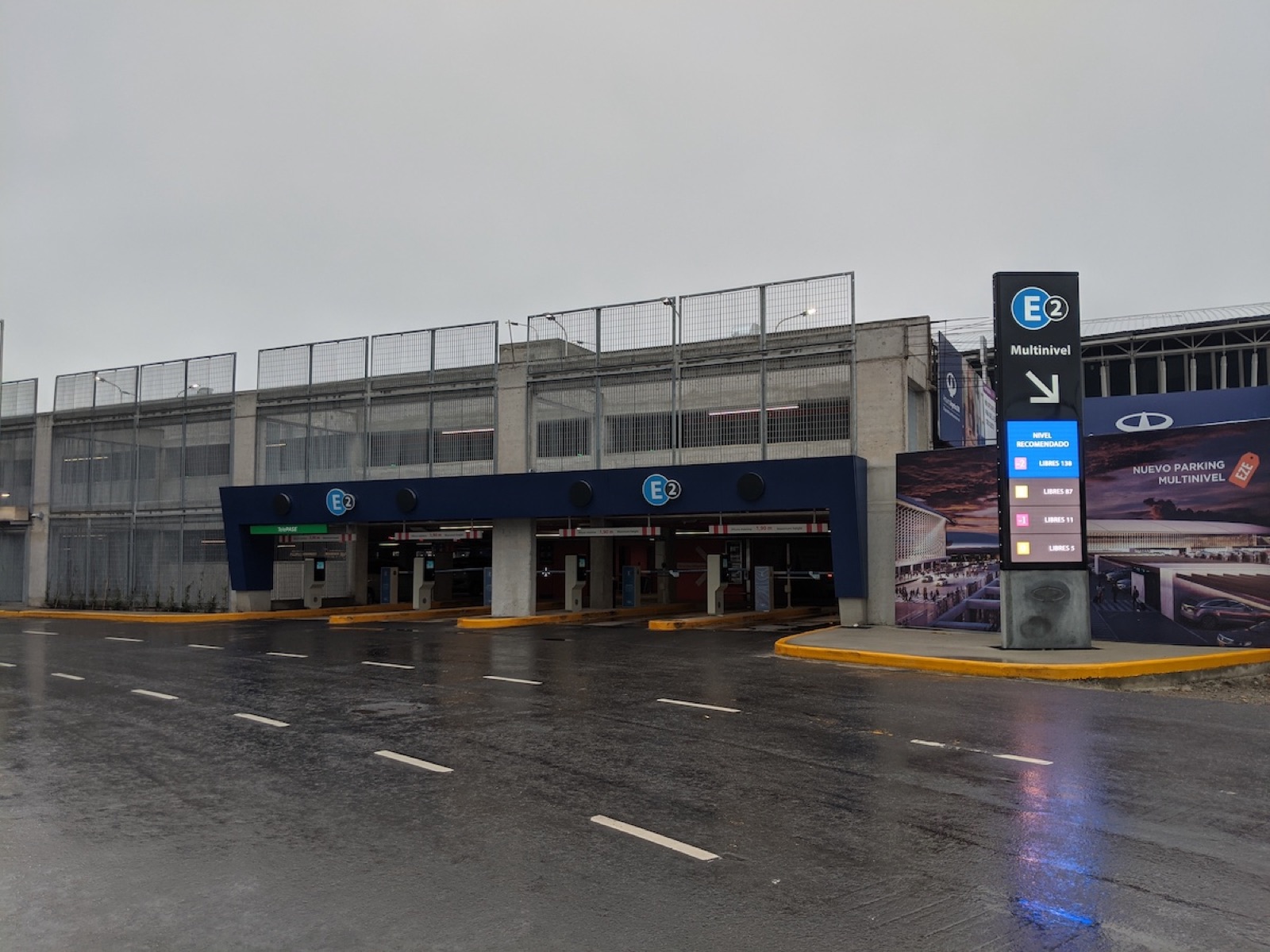The entrance to a multi-level airport car park with a digital totem showing free spaces per level.
